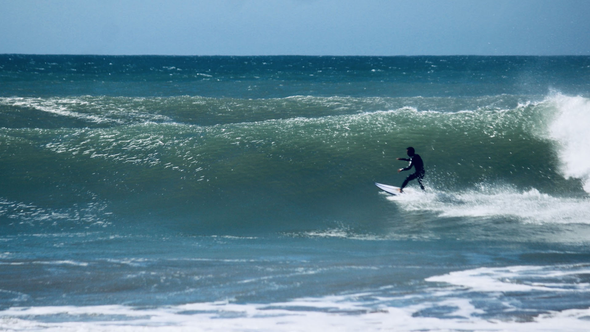 Intermediate surfer catching an unbroken green wave – key milestone