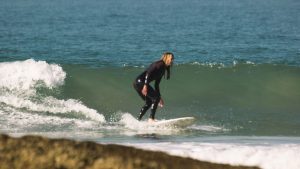 Summer surfing in Morocco – beginner catching a small wave at Banana Point Taghazout