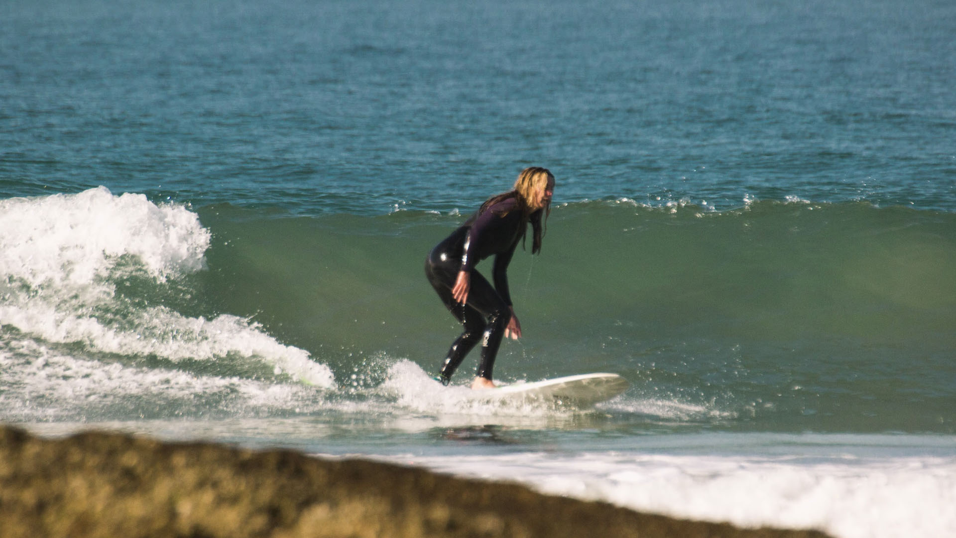 Summer surfing in Morocco – beginner catching a small wave at Banana Point Taghazout